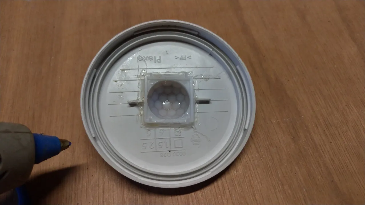 Usando pegamento caliente para fijar el sensor de movimiento del detector de ratones