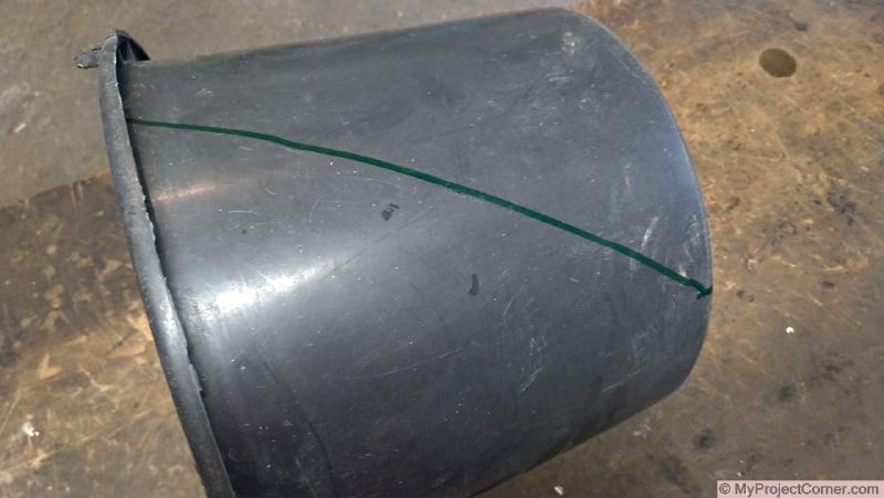 Marcando el fondo del cubo de plástico usado para el cono de matar pollos